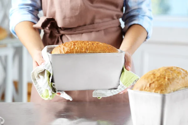 Bäcker überprüft frisch gebackenes Brot in Bäckereiküche — Stockfoto