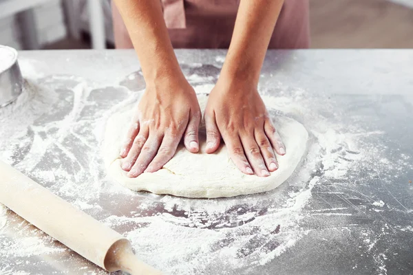 Fazendo a massa de farinha por mãos femininas na padaria — Fotografia de Stock