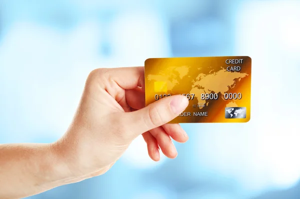Mão segurando cartão de crédito em fundo abstrato — Fotografia de Stock