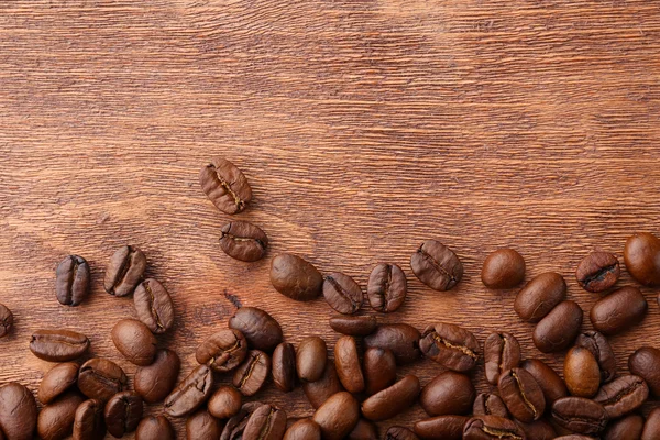 Chicchi di caffè su sfondo di legno — Foto Stock