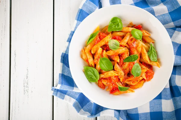 Pasta con salsa di pomodoro e basilico in tavola da vicino — Foto Stock