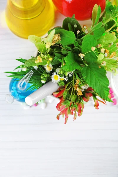 Ervas em argamassa, tubos de ensaio e comprimidos, sobre a mesa de fundo — Fotografia de Stock