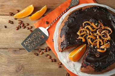 Kek çikolata sır ve turuncu ahşap arka plan üzerinde plaka üzerinde