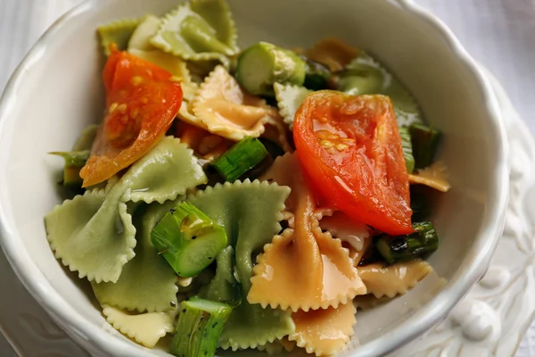 Rostad sparris och välsmakande pasta med grönsaker i skål på träbord bakgrund — Stockfoto