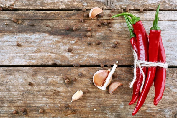 Pimientos rojos picantes con especias en la mesa de madera de cerca — Foto de Stock