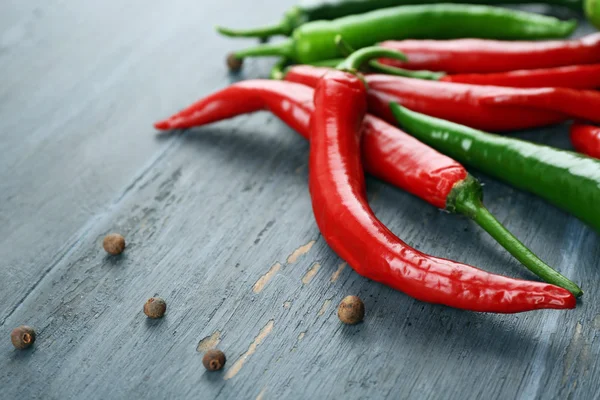 Hot peppers with spices on wooden table close up — Stock Photo, Image