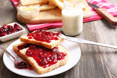 Ekmek tereyağı ve plaka üzerinde ahşap masa, tatlı, ev yapımı reçel ile