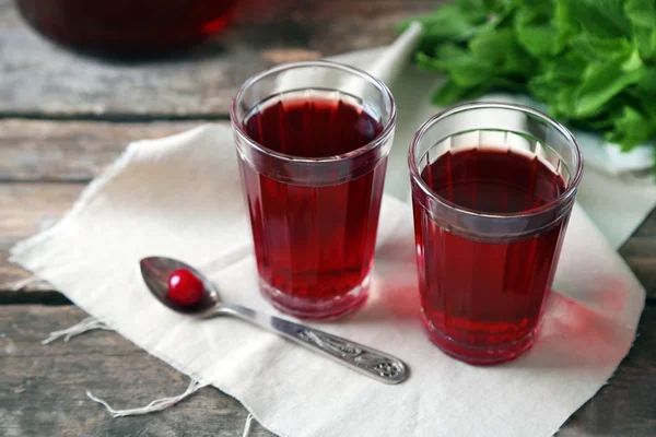 Two glasses with cherry juice on table, on wooden background — Stock Photo, Image