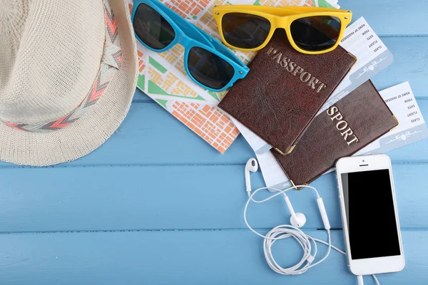Óculos de sol, passaportes, chapéus e mapa sobre fundo de madeira colorido. Preparação para o conceito de viagem — Fotografia de Stock