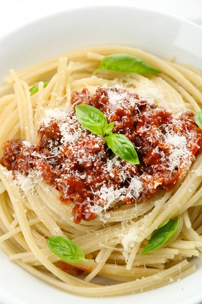 Спагетті Болонья з пармезановим сиром у білій мисці, на кольоровому дерев'яному фоні — стокове фото