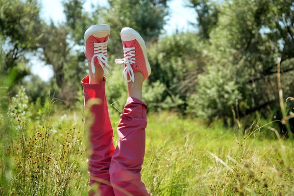 Женские ноги в разноцветных кроссовках — стоковое фото