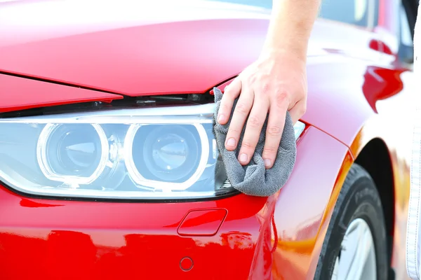 Męskiej ręki wycierania reflektory samochodu — Zdjęcie stockowe