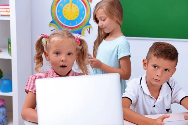 Группа детей за ноутбуком — стоковое фото