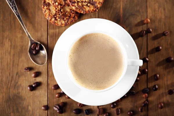 Tasse de café avec biscuits et grains de café sur table en bois, vue sur le dessus — Photo