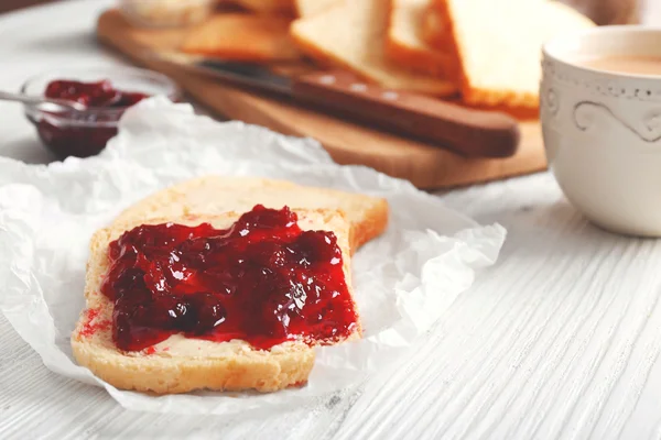 Bread with butter and homemade jam on crumpled parchment, closeup — Stock Photo, Image