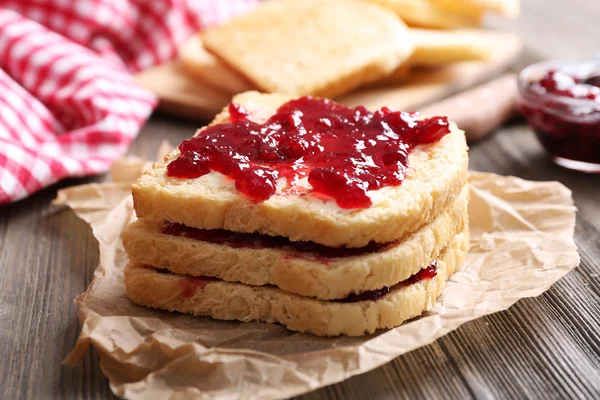 Brood met boter en zelfgemaakte jam op verfrommeld perkament, close-up — Stockfoto