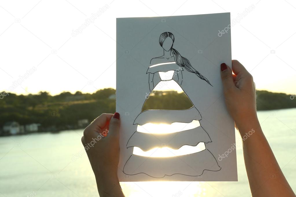 Woman in cutout dress on sheet of paper 