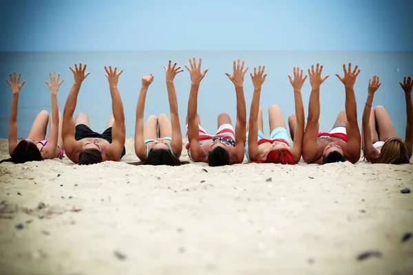 Young people lying on beach — Stock Photo, Image