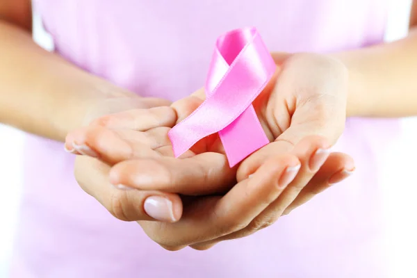 Pink ribbon in woman's hands — Stock Photo, Image