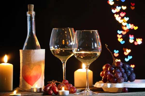 Bicchiere di vino vicino bottiglia su cuori bokeh sfondo — Foto Stock