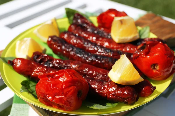 Embutidos a la parrilla con verduras en primer plano — Foto de Stock