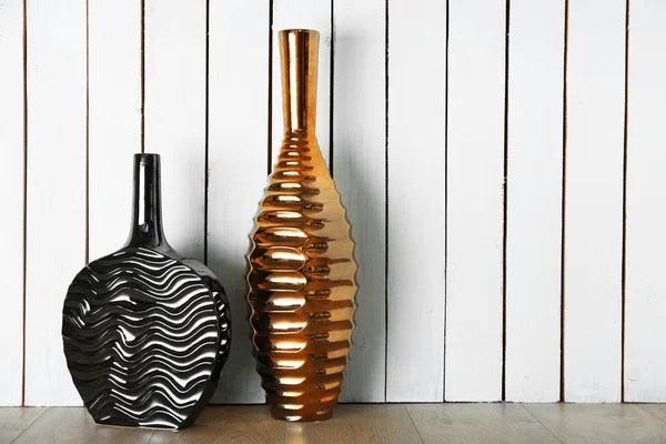 Beautiful vases on wooden wall background — Stock Photo, Image