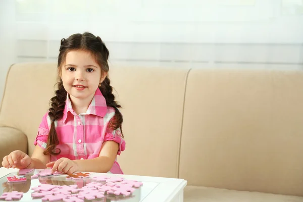Little girl playing with puzzles — Stock Photo, Image