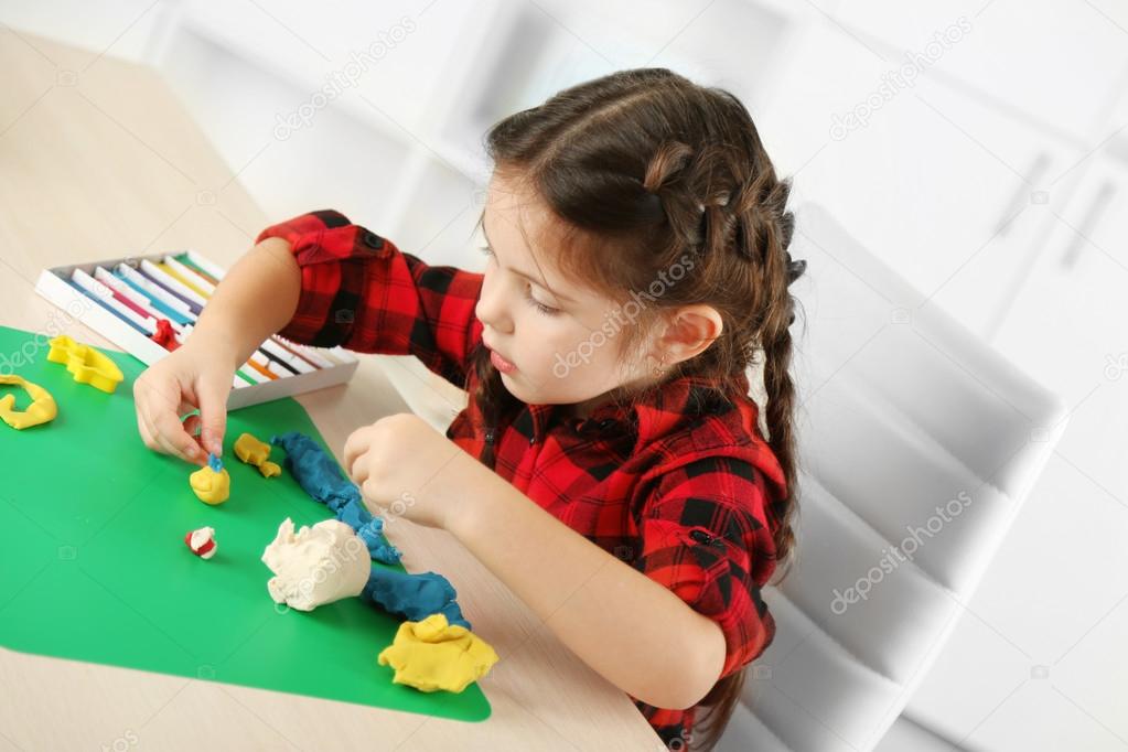 Cute little girl moulds from plasticine