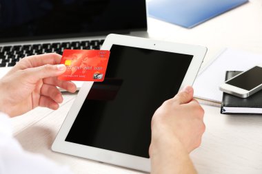 Kredi kartı ve tablet tutan adam
