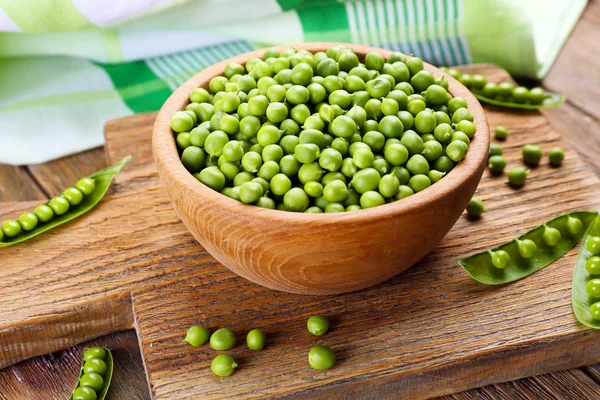 Pois verts frais dans un bol sur la table fermer — Photo