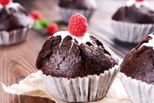 Deliciosos cupcakes de chocolate com bagas na mesa de perto — Fotografia de Stock