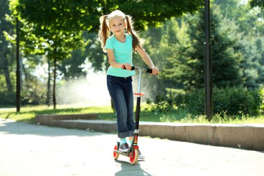 Kız scooter üzerinde sürme 