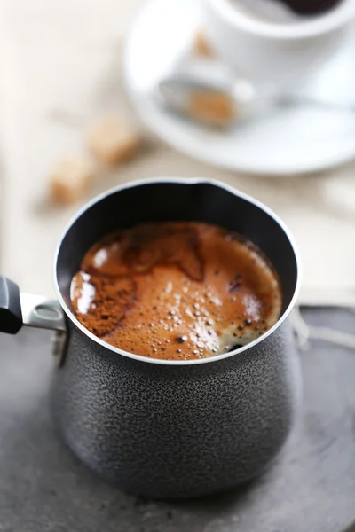 Turk of flavored coffee on table with napkin, closeup — Stock Photo, Image