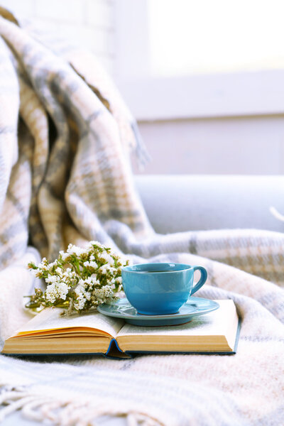 Синяя чашка кофе с открытой книгой
