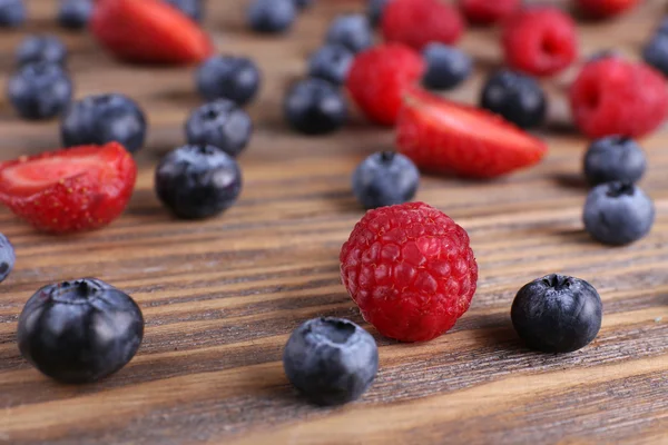 Leckere reife Beeren auf Holztisch — Stockfoto