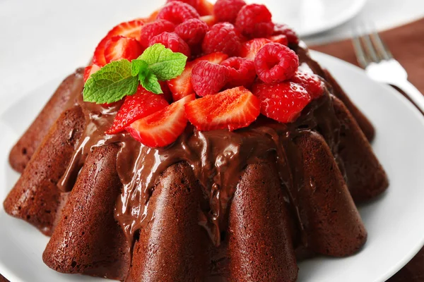 Chocolate muffin with glaze and berries — Stock Photo, Image