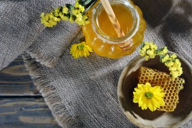 Kavanoz bal, petek ve çiçekler üzerinde çul, üstten görünüm