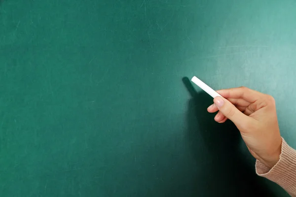 Female hand writing on blackboard — Stock Photo, Image