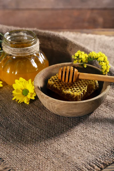 Maceta de miel, panal de abeja y cazo en tazón sobre tela de saco —  Fotos de Stock