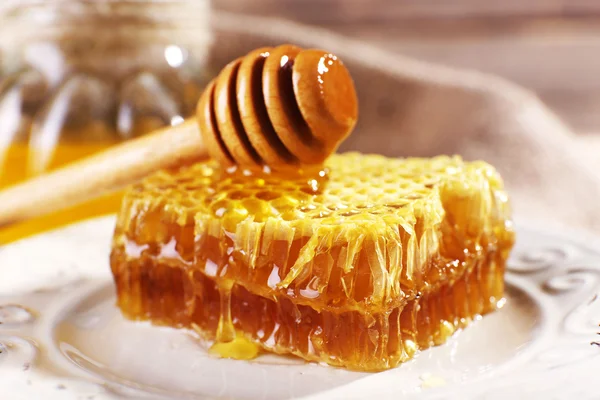 Panal de abeja, cazo en plato blanco y olla de miel de primer plano —  Fotos de Stock