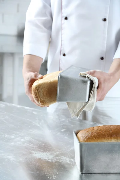 检查新烤的面包的面包师 — 图库照片