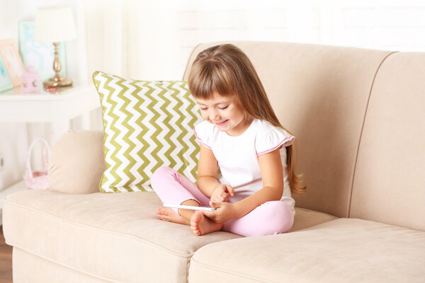 girl  with smart phone sitting on sofa