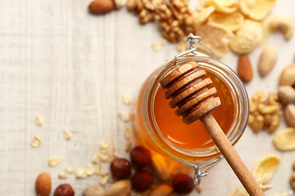 Miel en tarro de vidrio y frutos secos . — Foto de Stock