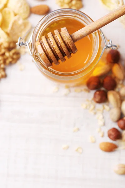 Honey in glass jar and nuts. — Stock Photo, Image