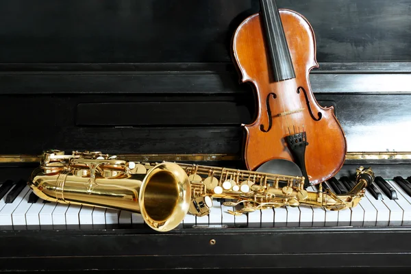 Geige und Saxophon auf Klavierhintergrund — Stockfoto