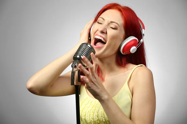 Hermosa mujer joven con micrófono y auriculares —  Fotos de Stock