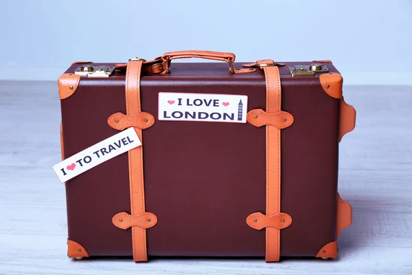 Suitcase with stickers on floor — Stock Photo, Image