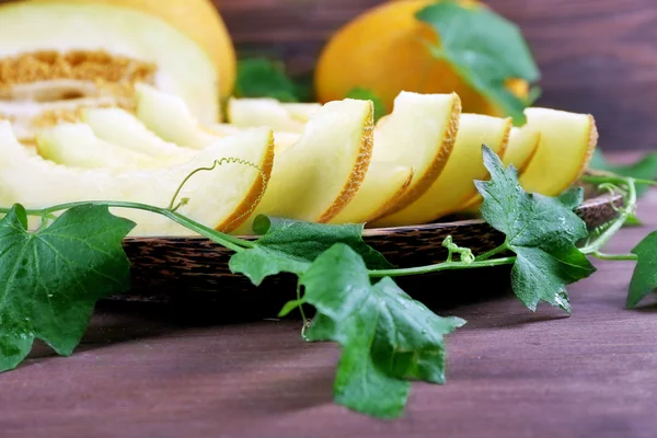 Slices of ripe melons with green leaves — Stock Photo, Image