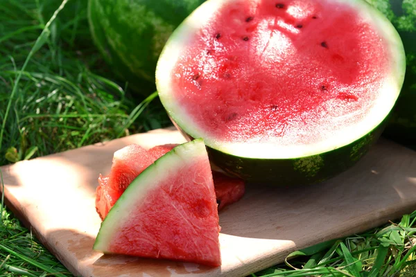 Frische Wassermelone über grünem Gras — Stockfoto
