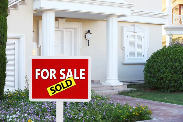 Real estate sign in front of new house for sale — Stock Photo, Image